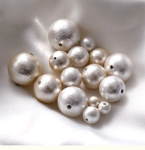 Macro shot of assorted size cotton pearls with silk texture for DIY jewelry making