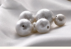 Macro shot of white textured cotton pearls with pre-drilled holes for DIY jewelry