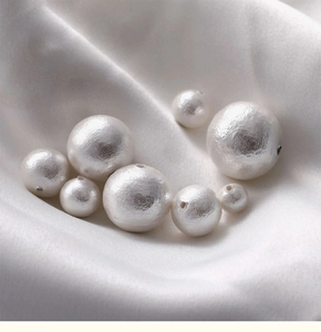 Macro shot of white textured cotton pearls in various sizes for DIY jewelry making
