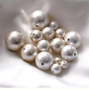 High-quality white and gold cotton pearls on silk background for DIY jewelry making