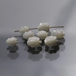 Macro detail of hand-carved white mother of pearl rose beads for DIY jewelry making