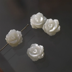 Macro shot of white mother of pearl carved rose beads for jewelry making DIY