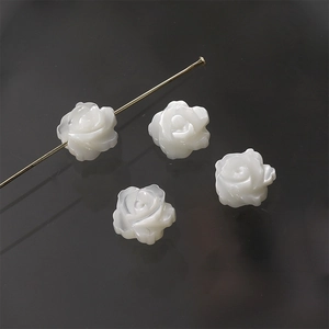 Macro detail of carved white mother of pearl rose beads for DIY jewelry making and crafts