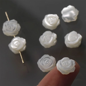 Macro detail of hand-carved white mother of pearl rose beads for DIY jewelry making
