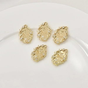 Makro-Detail von 14k vergoldeten ovalen Schleifenblumen-Anhängern mit Love-Gravur und Zirkon