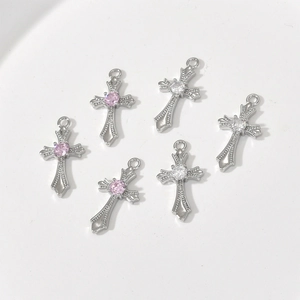 Detailed view of vintage 14k gold cross pendants with pink and white zircon stones