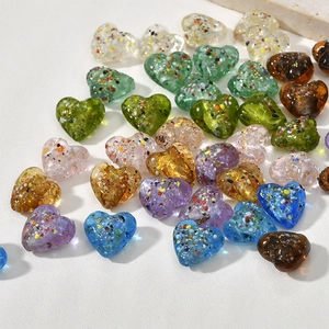 Dettaglio di perline a cuore 15mm in vetro con foglia d'argento colorata per gioielli fai-da-te