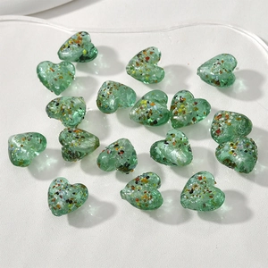 Dettaglio di perle a cuore in vetro verde da 15mm con scaglie colorate per gioielli