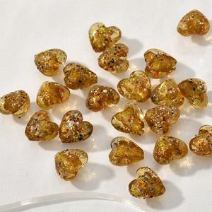 Dettaglio di perline a cuore in vetro ambrato da 15mm con scaglie colorate per gioielli
