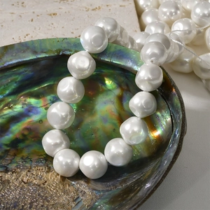 Macro detail of white baroque pearls with iridescent luster inside an abalone shell