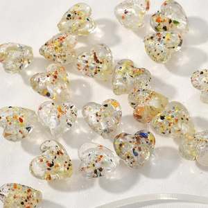 Dettaglio di perle a cuore in vetro da 15mm con scaglie d'argento colorate per DIY