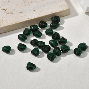 Macro view of irregular dark green glass beads with holes for DIY jewelry making