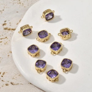 Macro shot of 14k gold-plated square purple zircon connectors with hollow metal patterns
