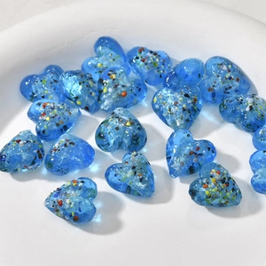 Dettaglio macro di perle di vetro a cuore blu con motivo millefiori colorato per gioielli