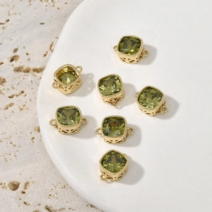 Macro shot of 14k gold-plated square green zircon pendants with hollowed side details