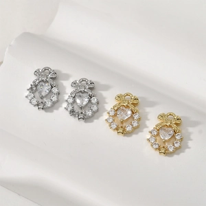 Vista macro di ciondoli a cuore con fiocco placcati in oro 14k con zirconi per gioielli DIY