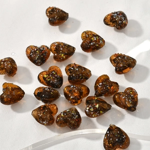 Dettaglio di perle a cuore in vetro ambra da 15mm con scaglie colorate per gioielli fai da te