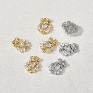 Dettaglio di ciondoli a cuore con fiocco e zirconi in oro e argento per gioielli DIY