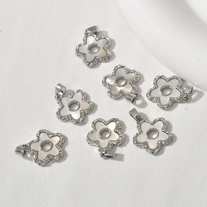 Close-up of 18k gold plated flower charms with white shell inlays for DIY jewelry making