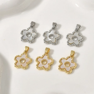 Detailed close-up of four-leaf flower pendants with shell inlay and 18k gold plating