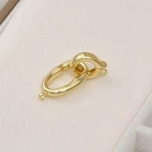 Detail of 14k gold-plated brass spring ring clasp with oval texture link for DIY jewelry