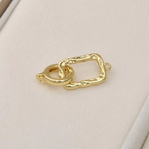 Macro shot of 14k gold plated textured rectangular clasp and spring ring connector