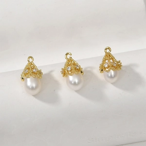 Dettaglio di pendenti di perle con cappucci in filigrana oro 14k e zirconi per gioielli fai da te