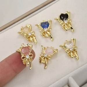 Détail de pendentifs bouquet de cœur plaqués or 14k avec nœud et zircons colorés