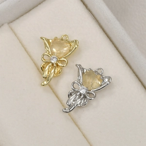 Détail macro de pendentifs nœuds en or 14k et rhodium avec zircon cœur en boîte