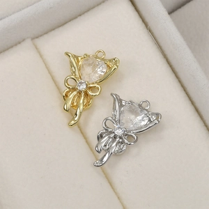 Détail de pendentifs cœur en zircon et nœud doré 14k sur un fond en velours