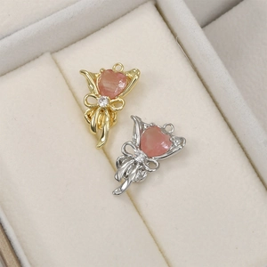 Détails macro des pendentifs fleurs en or et argent avec cristaux cœur roses