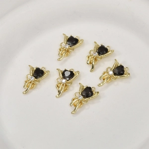 Détail de six pendentifs cœur en pierre noire avec cadres nœuds plaqués or 14 carats