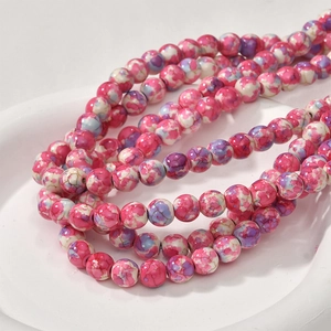 Macro shot of pink and white marble texture round beads in a white ceramic tray