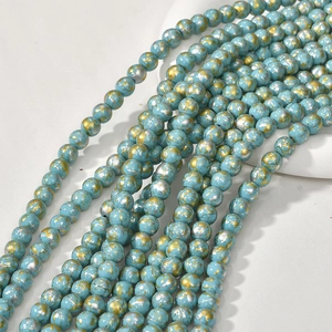 Macro detail of 8mm turquoise style round beads with gold and silver leaf texture for DIY jewelry