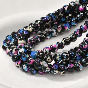 Macro detail of 8mm oil painting style round marble beads with blue and purple splashes