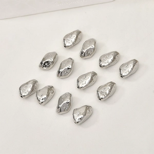 Close-up of irregular textured silver-plated beads for DIY jewelry making material