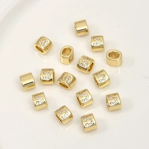 Macro detail of gold-plated cylinder spacer beads with pavé zircon number 5 for DIY jewelry