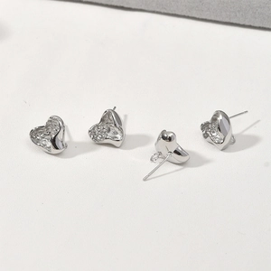 Detailed macro view of silver-plated lava texture heart earring studs for DIY jewelry making