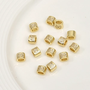 Close-up of 14k gold plated spacer beads with micro-set zircon and interlocking design