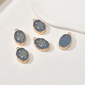 Detail van vijf vergulde ovale hangers met blauw email en sterpatroon voor DIY-sieraden