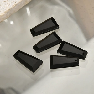 Macro shot of five black faceted trapezoid stones for DIY jewelry making and crafts