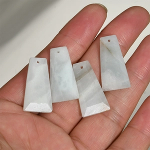 Macro detail of four natural trapezoid stone pendants showing unique mineral textures