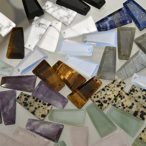 Macro display of diverse natural trapezoid gemstone pendants with pre-drilled holes for DIY