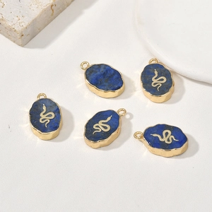 Detailopname van ovale lapis lazuli hangers met gouden slangenembleem voor sieraden
