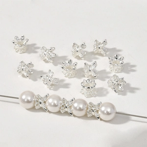 Detailed silver flower spacer beads layered with white pearls for DIY jewelry making