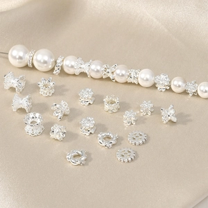 Close-up of silver flower spacer beads and rhinestone charms for DIY jewelry making