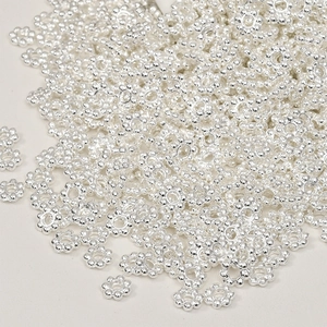 Close-up of thick silver-plated snowflake spacer beads for DIY jewelry making