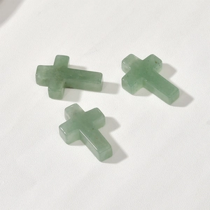 Detailed view of three polished light green natural aventurine stone cross pendants