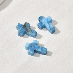Detailed view of three blue lace agate cross pendants with unique natural banded textures