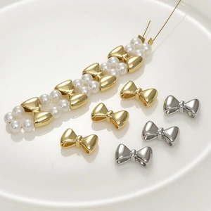 Macro shot of 14k gold-plated bow-shaped spacer beads for DIY jewelry making
